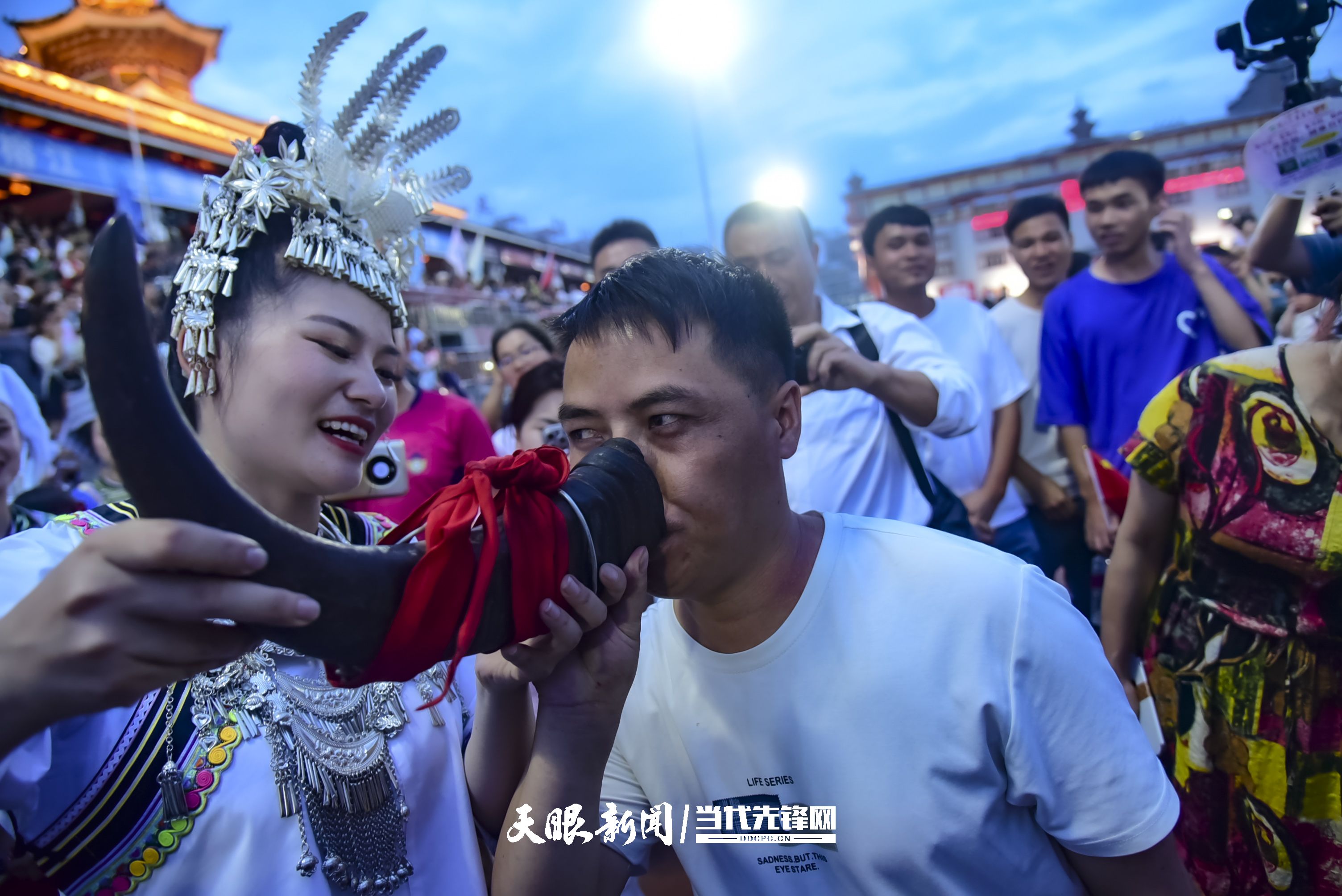 村超現(xiàn)場，當?shù)厝罕娤蜻h道而來的游客敬酒。 潘邵平 攝.jpg