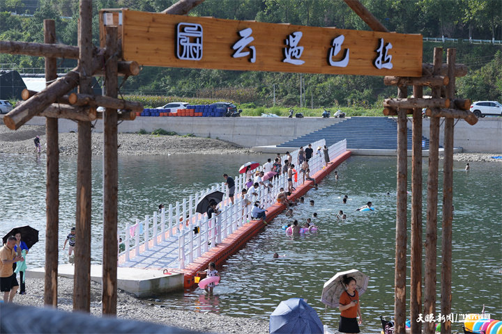 游客們?cè)陉?yáng)芳村河邊玩水嬉戲（錢(qián)仕豪 攝）.jpg